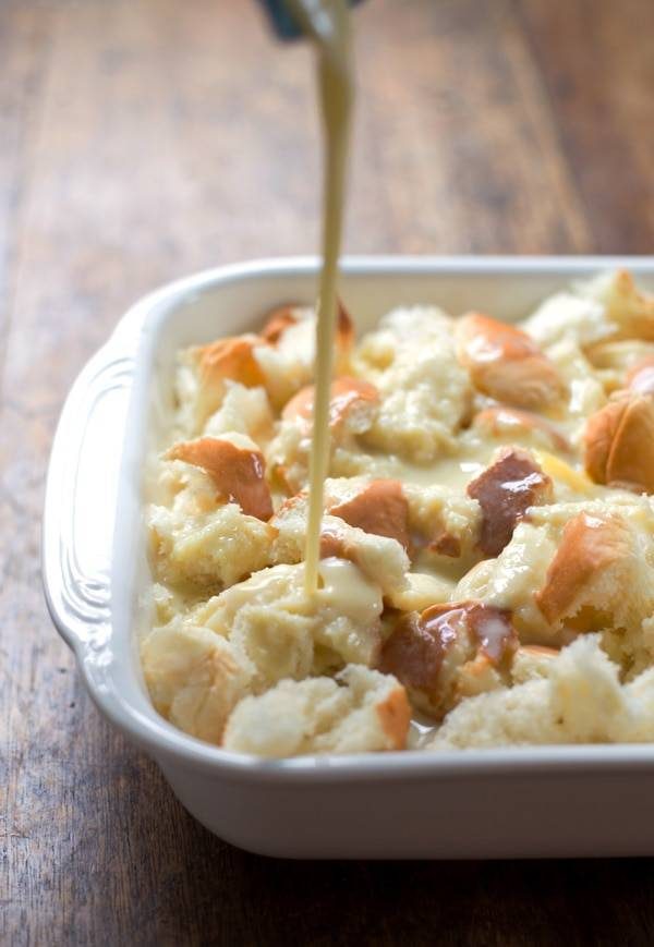 Pieces of bread with drizzle in a white baking dish.