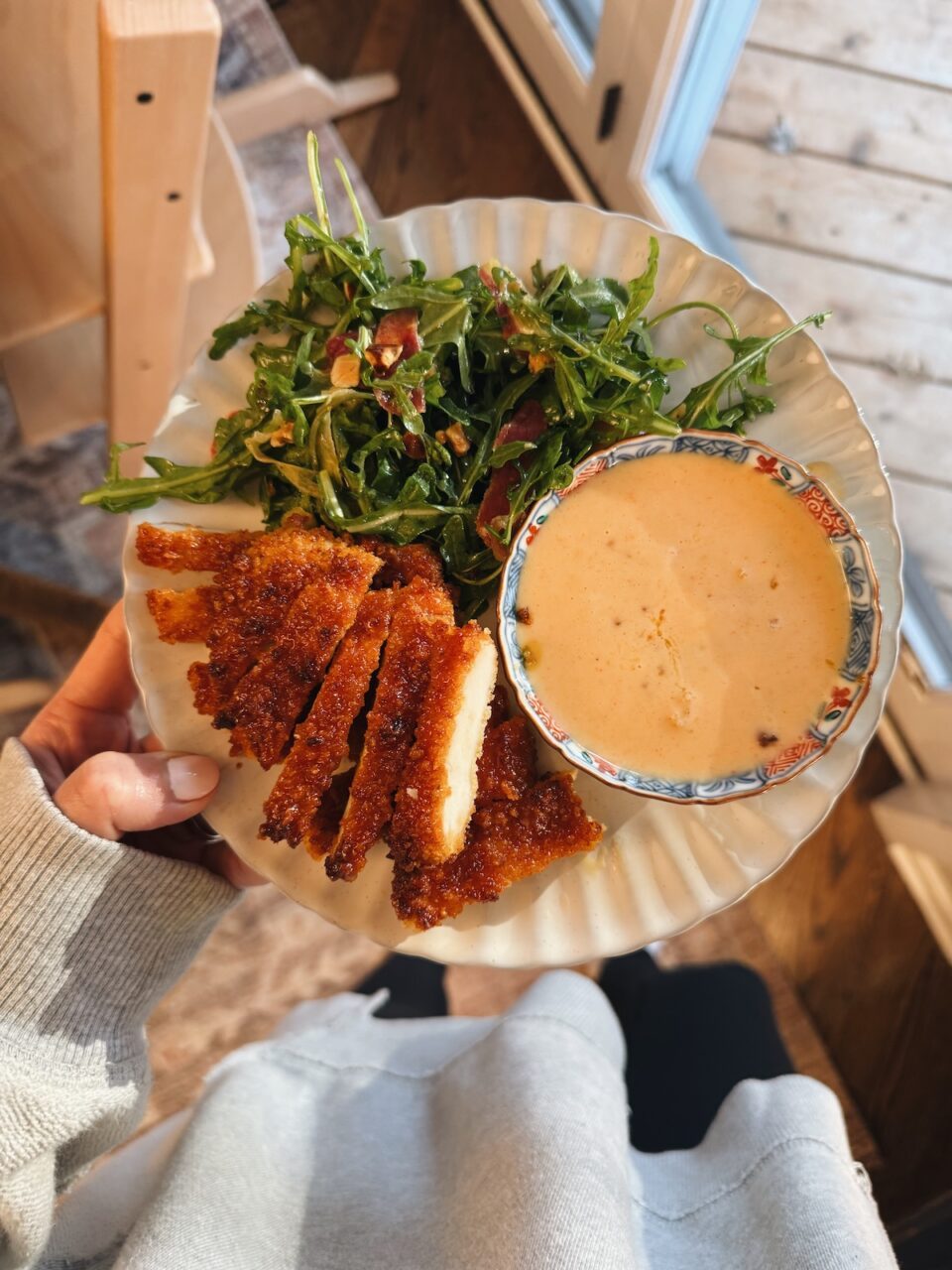 Gochujang chicken on a plate with salad and yum yum sauce.
