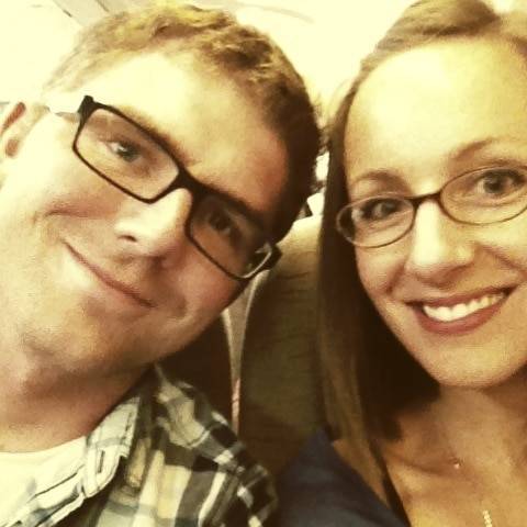 Man and woman wearing glasses smiling.