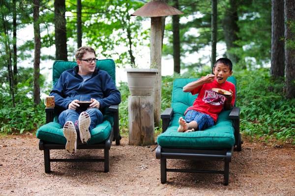 Man and young boy sitting in chairs.