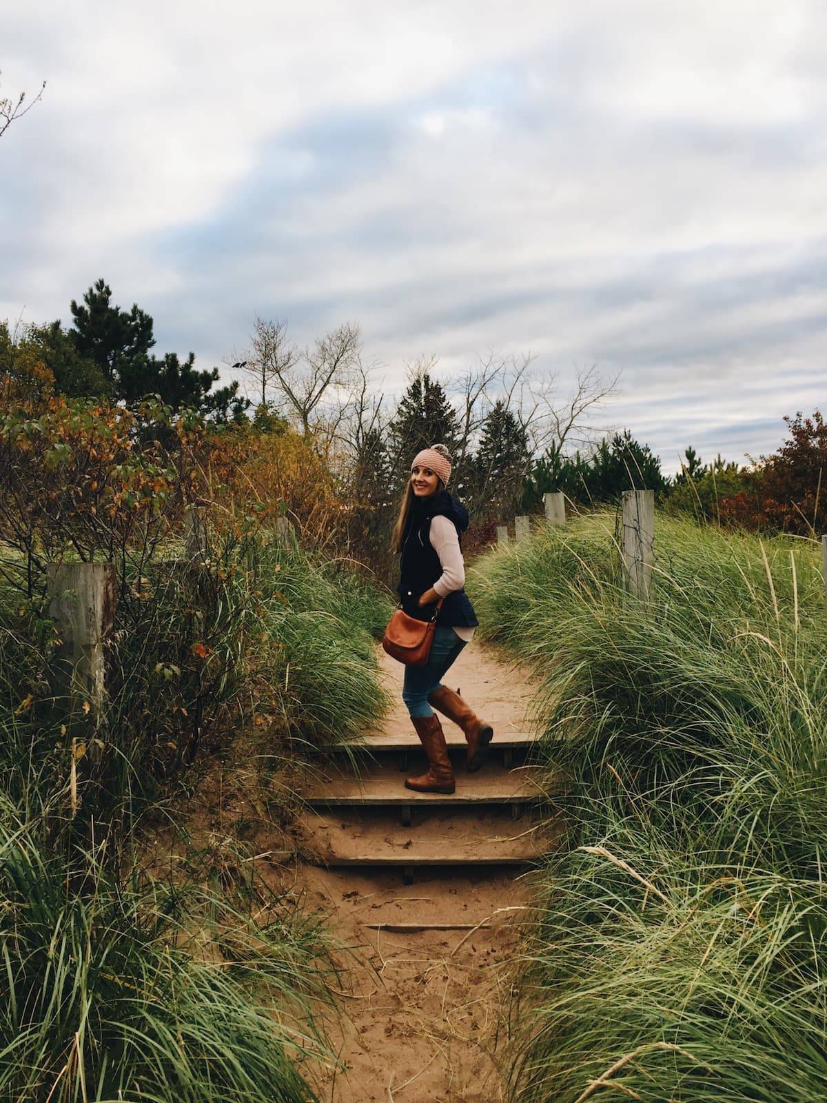 Woman standing on stairs outside.